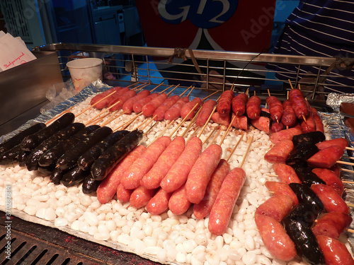 Close up shot of many different flavor sausage grilling on the stones © Kit Leong
