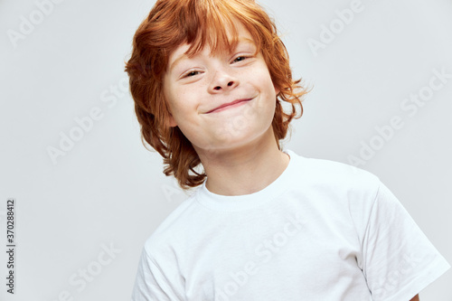 funny redhead boy smile white t-shirt cropped view gray isolated background