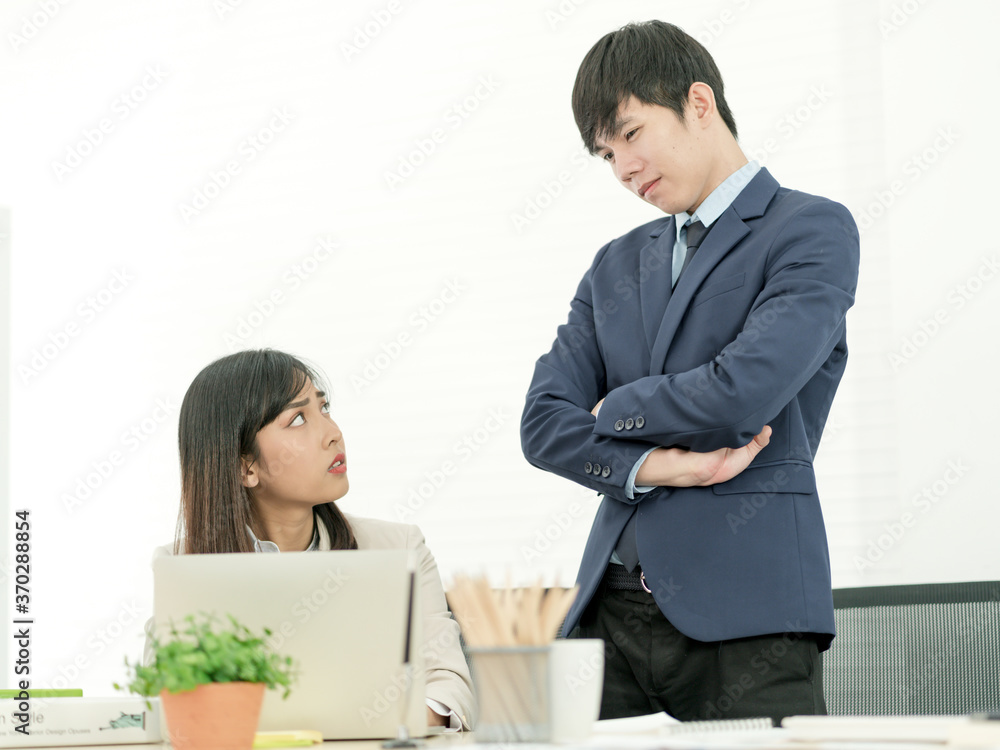 Asian business people having a casual discussion. Staff standing and discussing work in office.