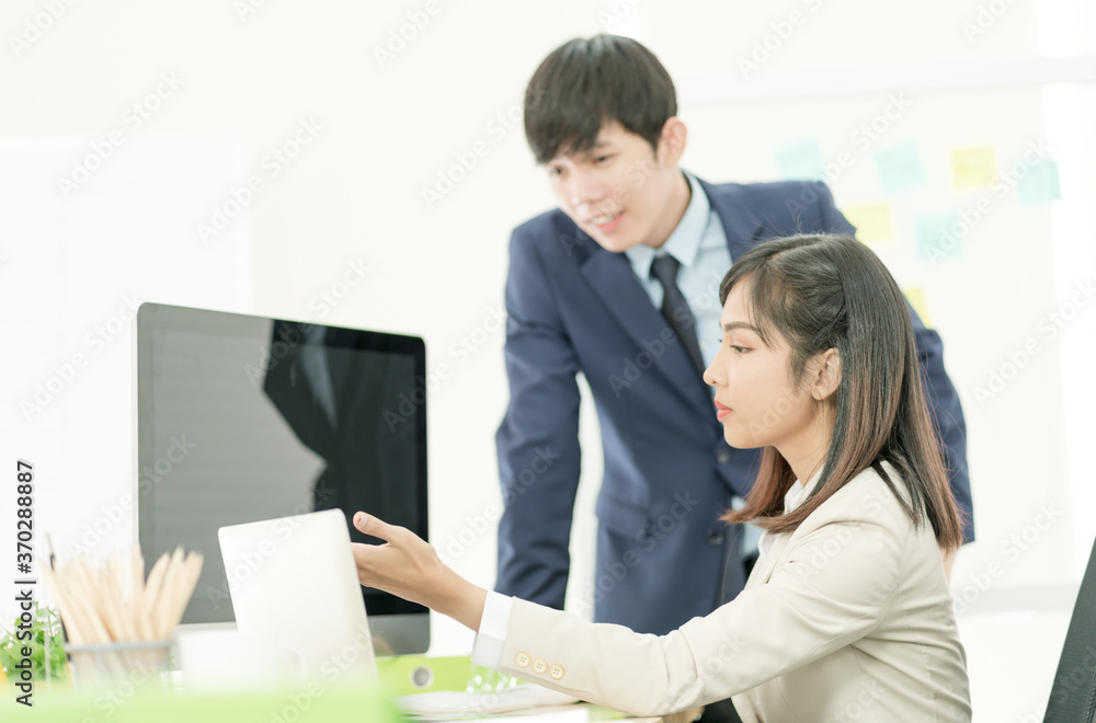 Asian business people having a casual discussion. Staff standing and discussing work in office. Asian business people having a casual discussion. Staff standing and discussing work in office.