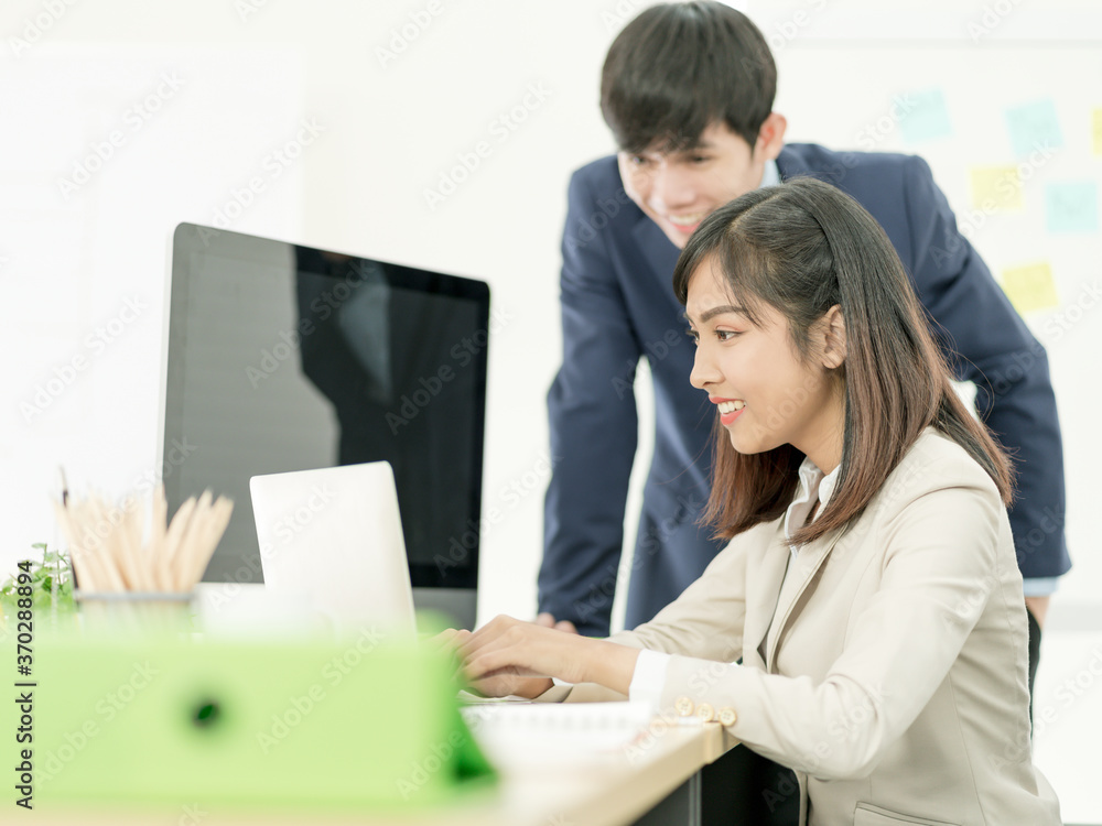 Asian business people having a casual discussion. Staff standing and discussing work in office. Asian business people having a casual discussion. Staff standing and discussing work in office.