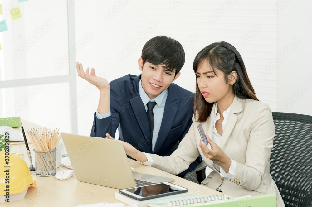Asian woman holding credit card and using laptop computer in office for online shopping and internet banking with her staff. Asian woman holding credit card and using laptop computer in office for online shopping and internet banking with her staff.