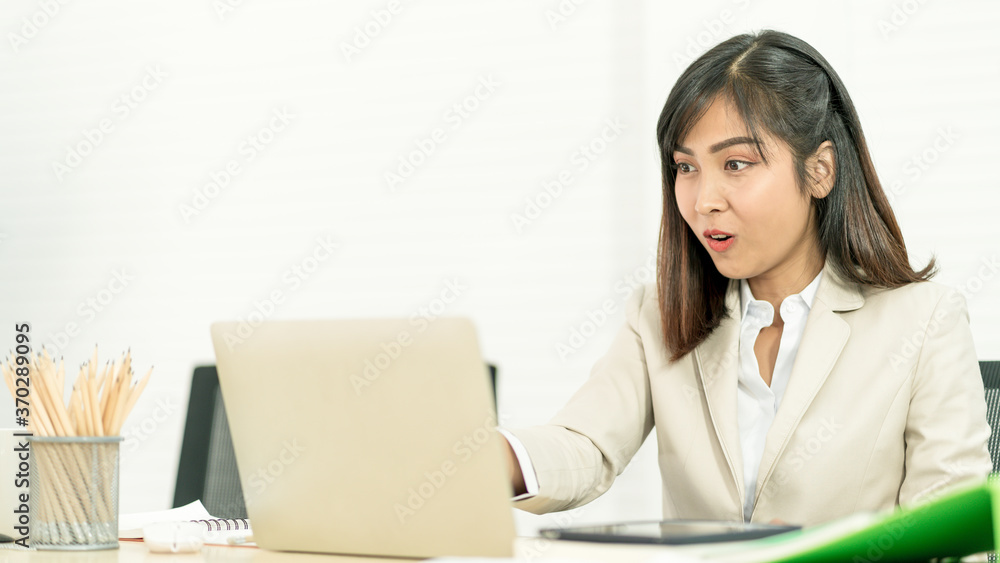 Asian business woman working at her office via laptop. Young female manager using computer at workplace Asian business woman working at her office via laptop. Young female manager using computer at workplace
