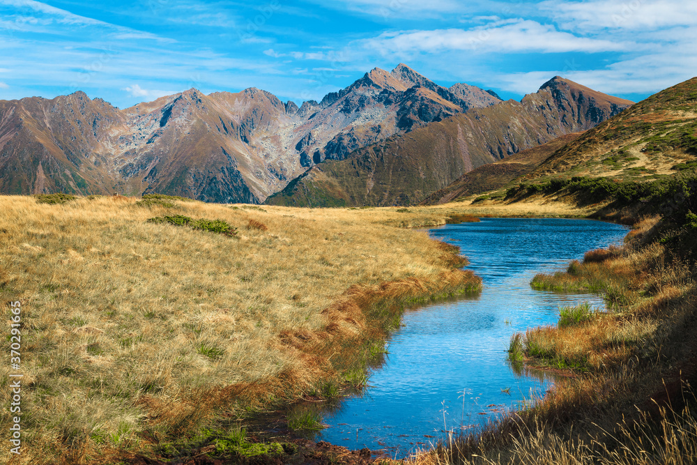 Beautiful small alpine lake with high peaks in background, Romania