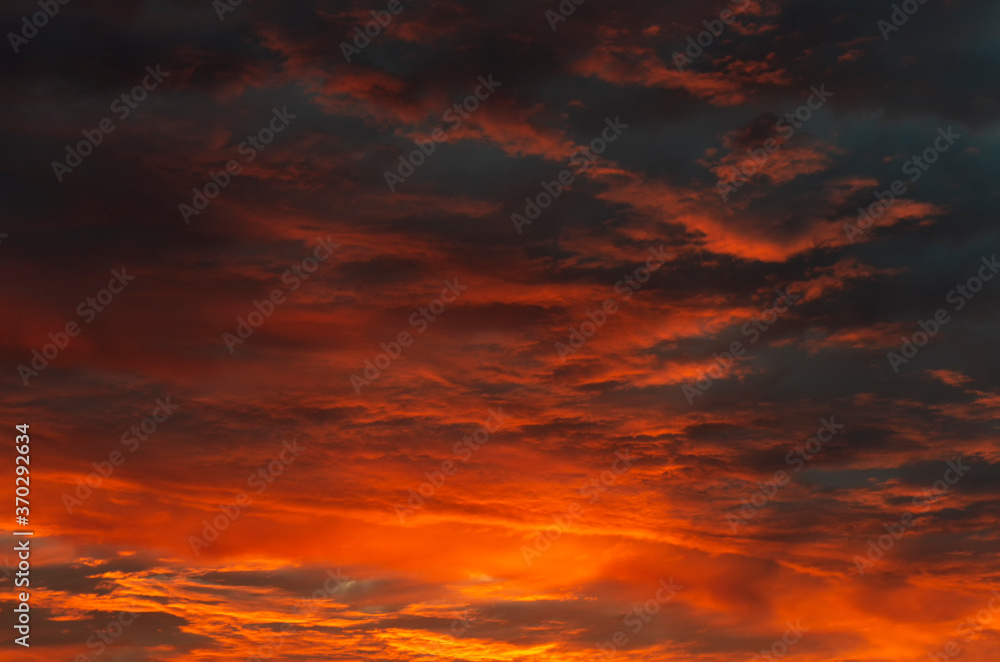 Dramatic sky with clouds gradient from black at the top to yellow-orange at the bottom during sunset