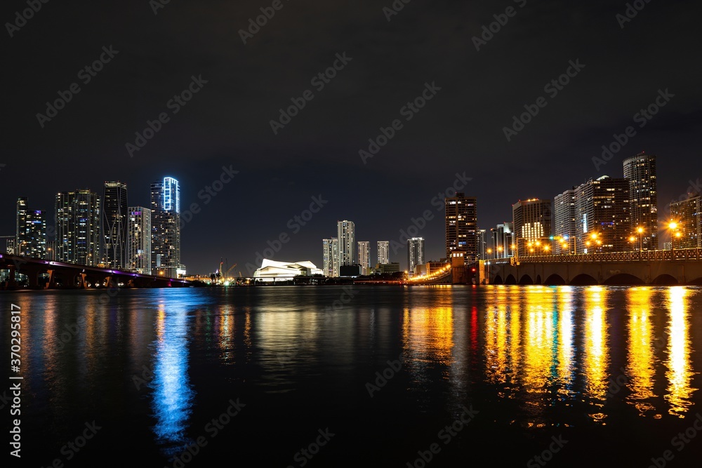 Miami city night. Miami Florida, sunset panorama with colorful illuminated business and residential buildings and bridge on Biscayne Bay.