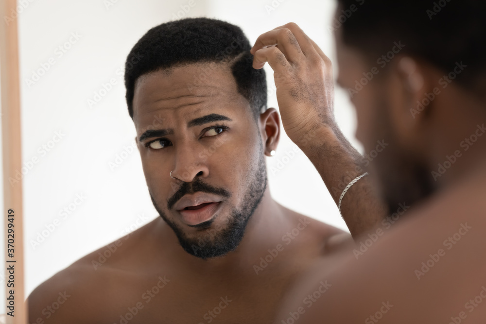 Stockfoto Close up anxious unhappy African American man checking hair after  shower, looking in mirror, standing in bathroom at home, dissatisfied by hair  loss or dandruff, healthcare and beauty concept | Adobe