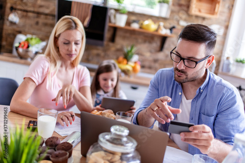 Young family pay bills with credit card.
