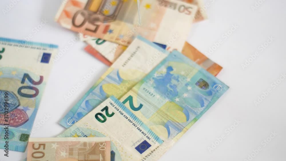 Close-up shot of euro banknotes falling on white table Close-up shot of euro banknotes falling on white table