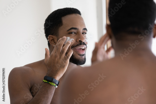 Konstfotografi Close up mirror reflection positive African American handsome young man applying