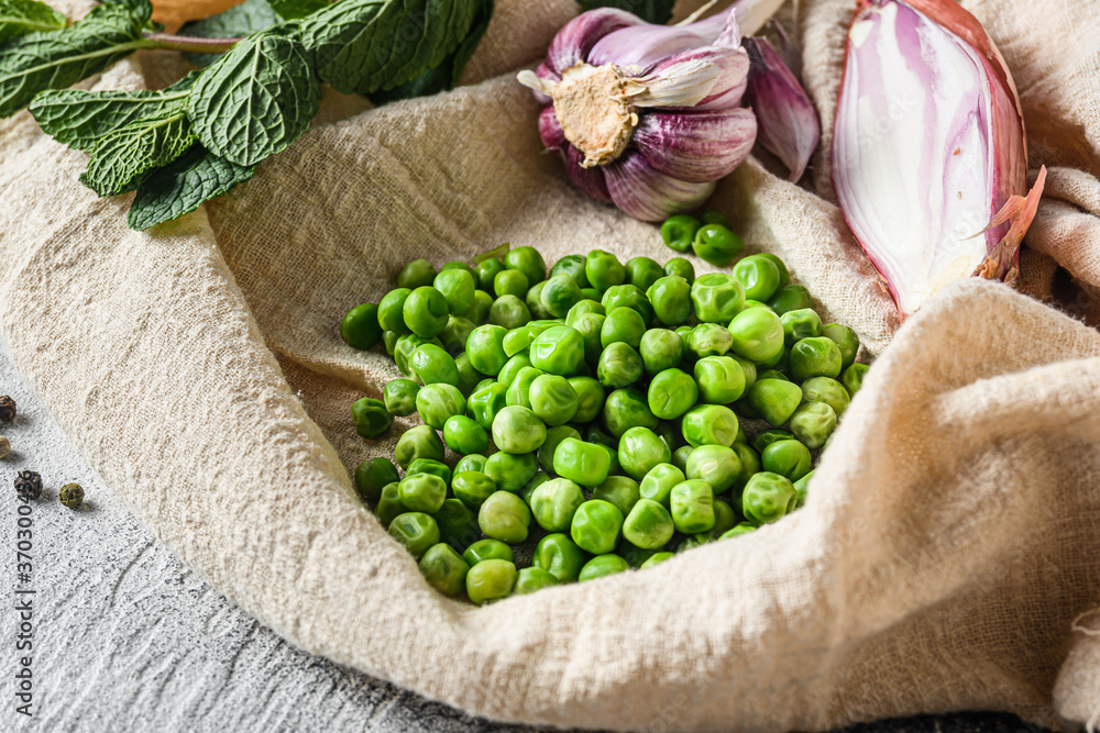 organic green peas for mushypeas and  ingredients peas mint shallot pepper and salt  keto food  photo over grey stone background and cloth side view close up