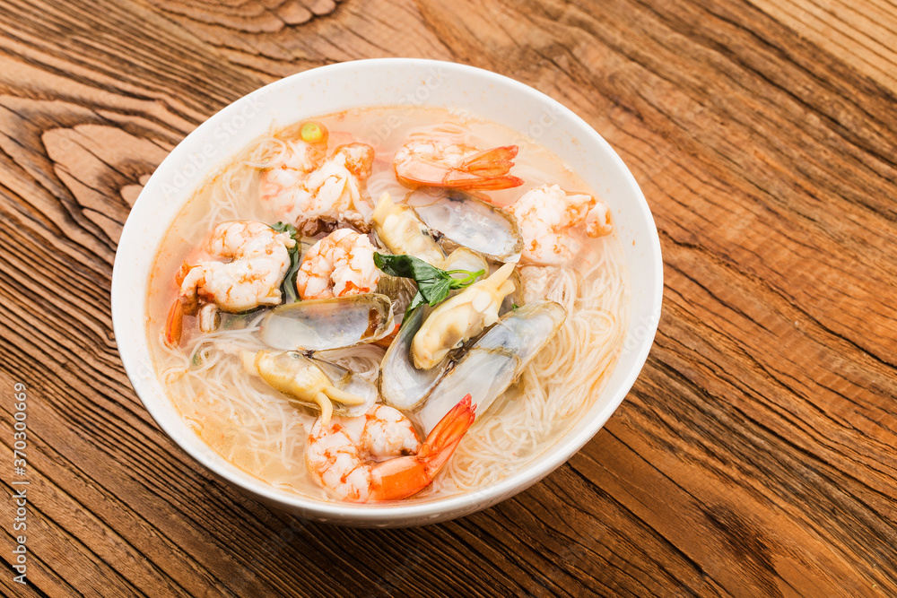 A bowl of rice noodles with shrimp and razor clams