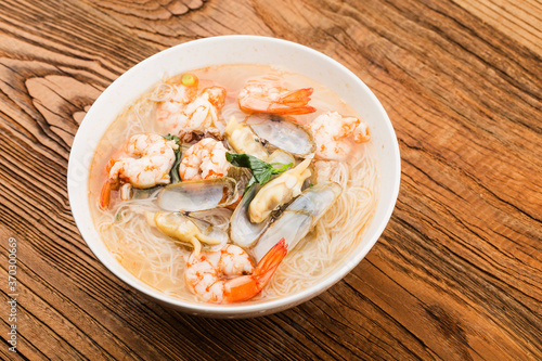 A bowl of rice noodles with shrimp and razor clams