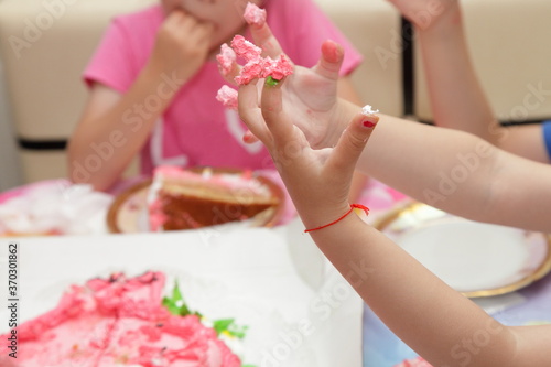 Children's hands in a pink birthday cake close up, birthday kid's entertainment