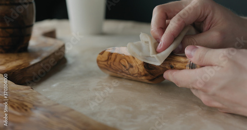 woodworker applying oil finish to olive wood scoop