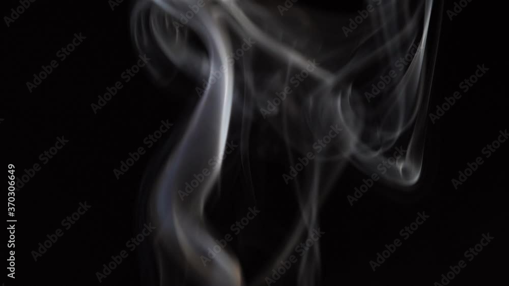 White smoke on black background in slow motion. White steam spins and rises White smoke on black background in slow motion. White steam spins and rises