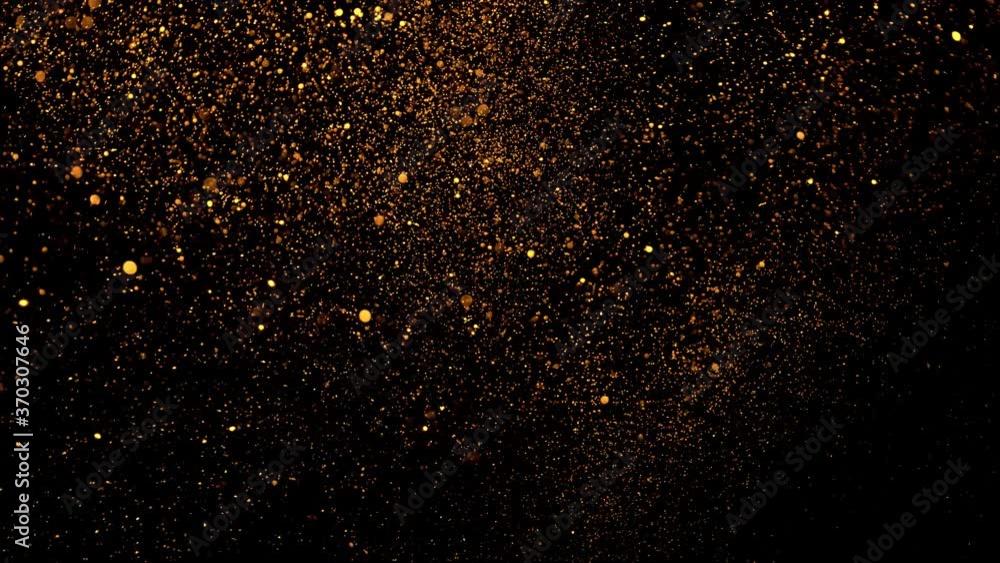 Real golden glitter shot in slow motion. Clouds of gold particles flying in wind on black background. Gold dust beautiful bokeh abstract background. Golden Particles ( glitters background ) . Real golden glitter shot in slow motion. Clouds of gold particles flying in wind on black background. Gold dust beautiful bokeh abstract background. Golden Particles ( glitters background ) .