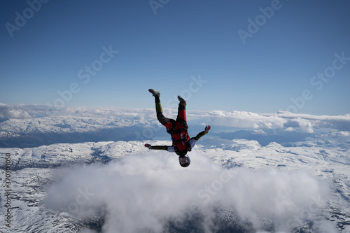 Vászonkép Skydivers over snowy mountains in Norway