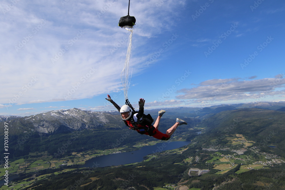 Fototapeta premium Skydivers over snowy mountains in Norway