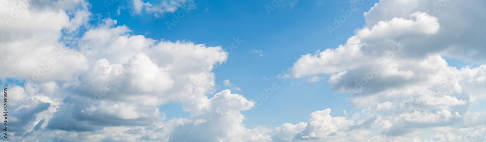 Blue skies on a clear day. White cumulus clouds float across the sky. Blue skies on a clear day. White cumulus clouds float across the sky.