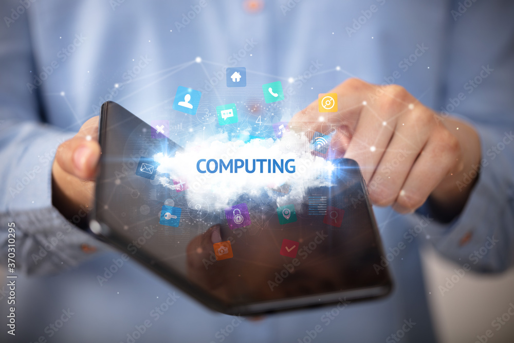 Businessman holding a foldable smartphone with COMPUTING inscription, technology concept Businessman holding a foldable smartphone with COMPUTING inscription, technology concept