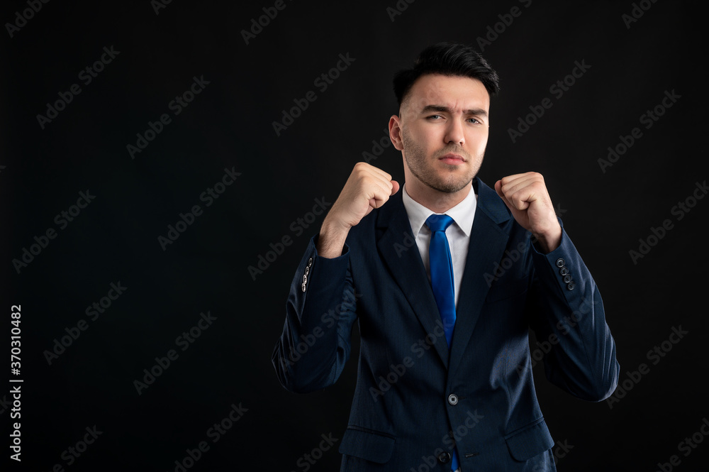 Portrait of business man wearing blue business suit and tie showing fists like fighting Portrait of business man wearing blue business suit and tie showing fists like fighting