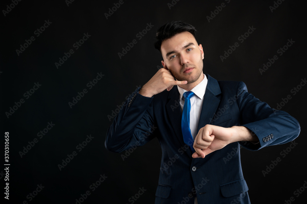 Portrait of business man wearing blue business suit and tie showing it's time gesture Portrait of business man wearing blue business suit and tie showing it's time gesture