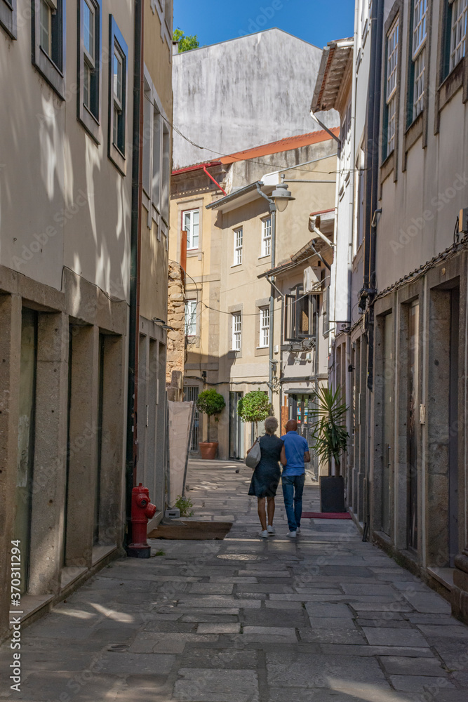 Older Couple Walking Down European Alley With Shops, Portugal