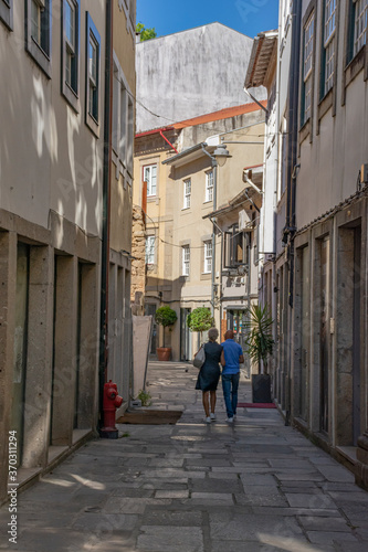 Older Couple Walking Down European Alley With Shops, Portugal