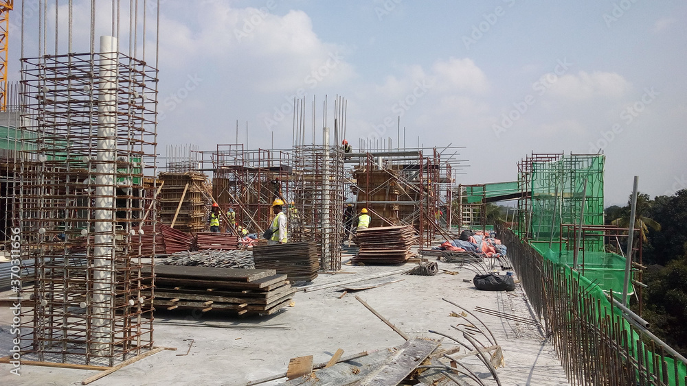 KUALA LUMPUR, MALAYSIA -AUGUST 23, 2019: Construction workers working at the construction site in Malaysia during the daytime. They are required to wearing appropriate safety gear to avoid an accident