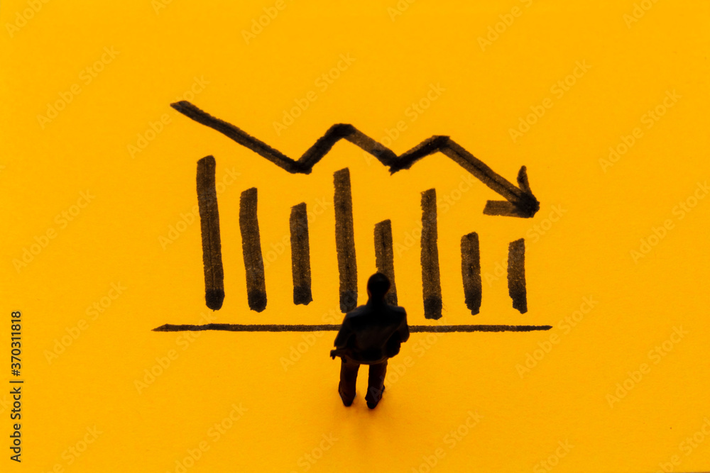 Miniature figurine posed as businessman in front of descending graph, negative performance concept image