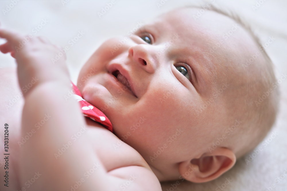 4 months old infant baby boy at changing table, detail on his head, red white dot bow over neck 4 months old infant baby boy at changing table, detail on his head, red white dot bow over neck