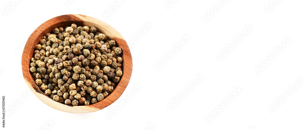 Dried white and green pepper corns in small wooden bowl - view form above isolated on white background space for text right side Dried white and green pepper corns in small wooden bowl - view form above isolated on white background space for text right side