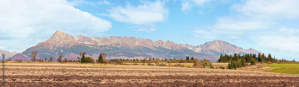 Mount Krivan peak (Slovak symbol) wide panorama with autumn dry field in foreground, Typical autumnal scenery of Liptov region, Slovakia Mount Krivan peak (Slovak symbol) wide panorama with autumn dry field in foreground, Typical autumnal scenery of Liptov region, Slovakia