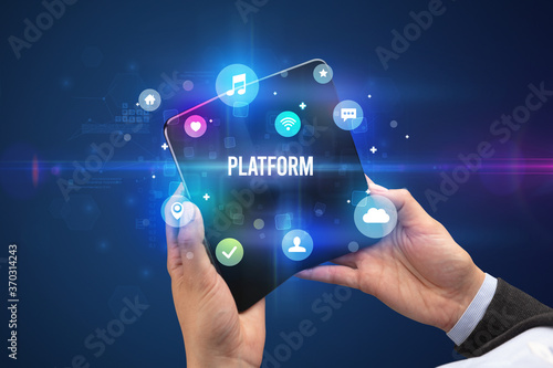 Businessman holding a foldable smartphone with PLATFORM inscription, social media concept