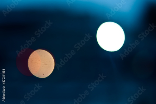 City traffic lights at night   abstract blurry circles in rear view mirror