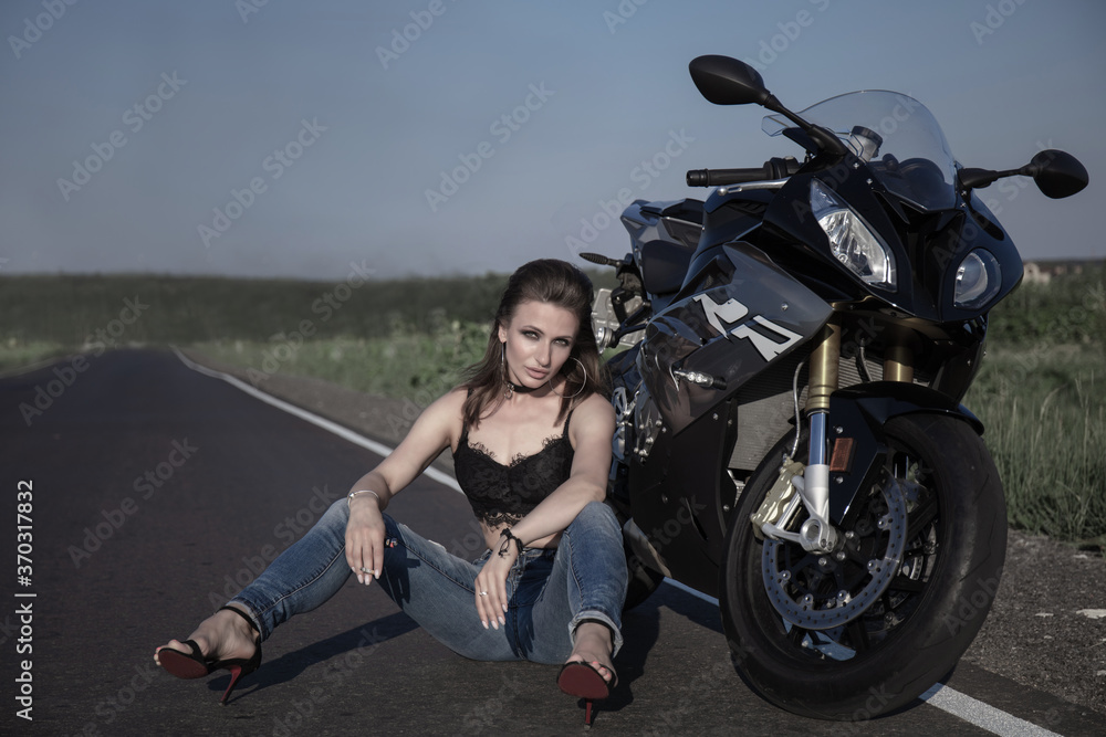 Obraz premium Beautiful woman with a motorcycle