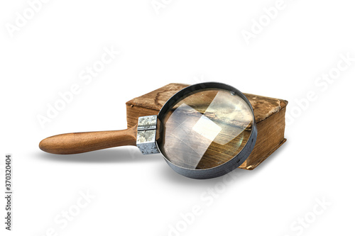 Ancient book and magnifier isolated on white