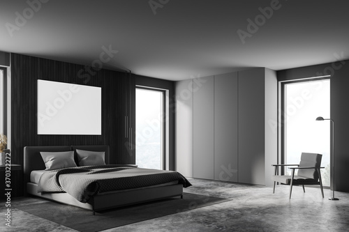Grey bedroom interior with poster and armchair