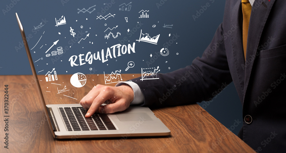 Businessman working on laptop with REGULATION inscription, modern business concept Businessman working on laptop with REGULATION inscription, modern business concept