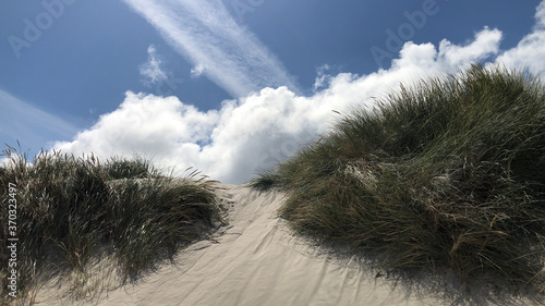 Weiße Wolken mit Düne