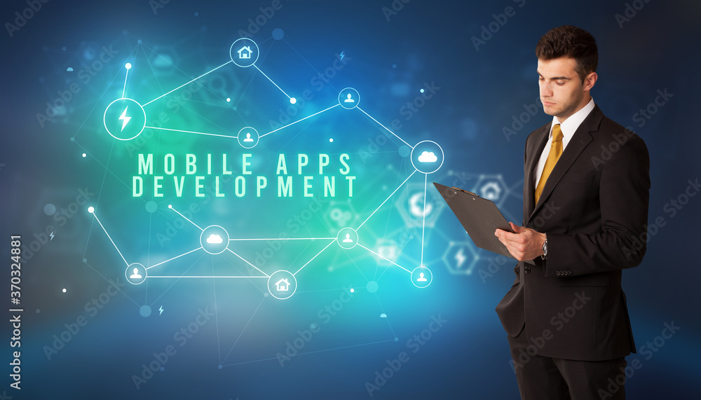 Businessman in front of cloud service icons with MOBILE APPS DEVELOPMENT inscription, modern technology concept Businessman in front of cloud service icons with MOBILE APPS DEVELOPMENT inscription, modern technology concept
