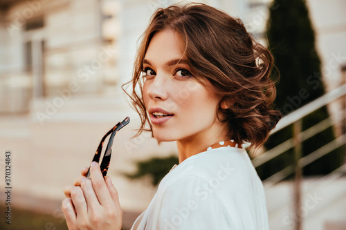 Cuadro en lienzo Sensual young woman in white blouse looking over shoulder