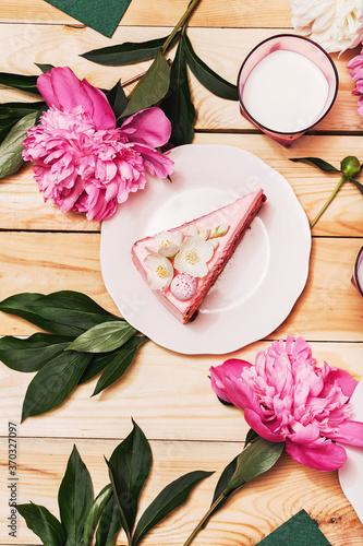 Pink cake on plate with pink peonies and milk