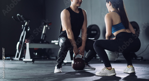 Sporty team with kettlebells and exercise workout at fitness gym.