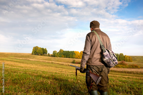  The man is on the hunt. Autumn hunting season. Man hunter with a gun. Copy space. © Sergey