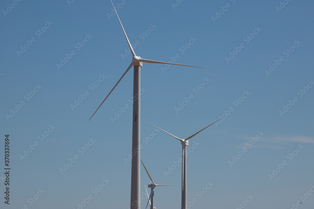 ветряная электWind Generator Turbine in Bright Sun Light on the Clear Blue Sky Background. High quality photo ветряная электWind Generator Turbine in Bright Sun Light on the Clear Blue Sky Background. High quality photo