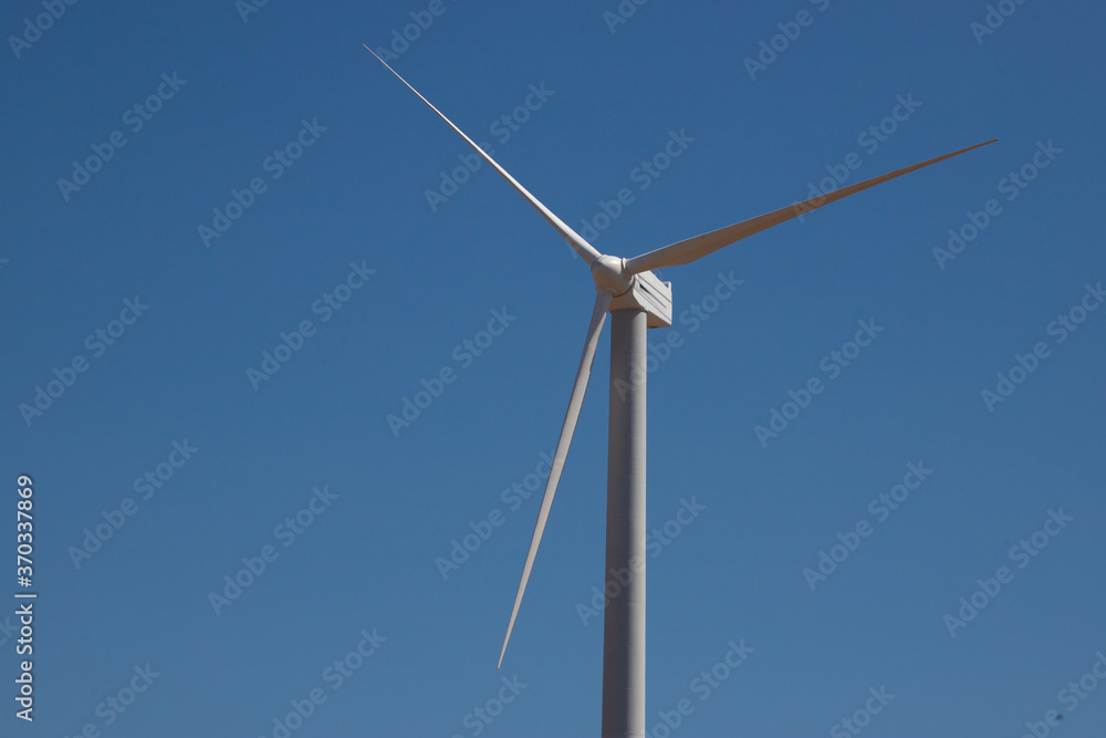 ветряная электWind Generator Turbine in Bright Sun Light on the Clear Blue Sky Background. High quality photo ветряная электWind Generator Turbine in Bright Sun Light on the Clear Blue Sky Background. High quality photo