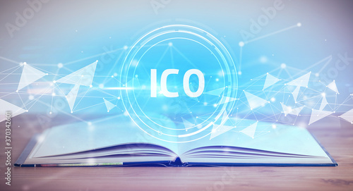 Open book with ICO abbreviation, modern technology concept