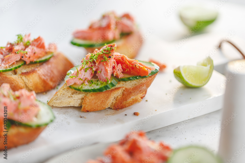 Toasts with fresh cucumber and smoked salmon served with lime shavings Toasts with fresh cucumber and smoked salmon served with lime shavings